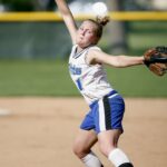 concentrated female baseball pitcher throwing baseball