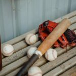 baseball bat and balls on a bench